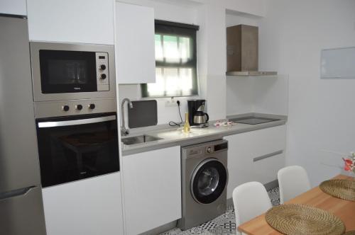 a kitchen with a washing machine and a microwave at Casa Rural Guadá in Valle Gran Rey