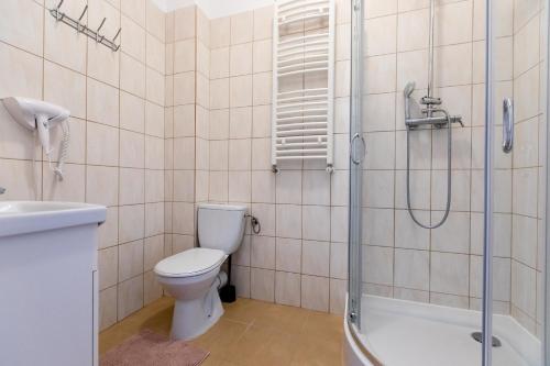 a bathroom with a toilet and a shower and a sink at Apartament AKWAMARYN z bezpłatnym parkingiem Dziwnówek nad morzem 250m od plaży Epapartamenty in Dziwnówek