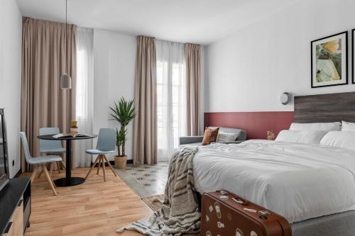 a bedroom with a large bed and a table and chairs at Bob W Arte in Madrid