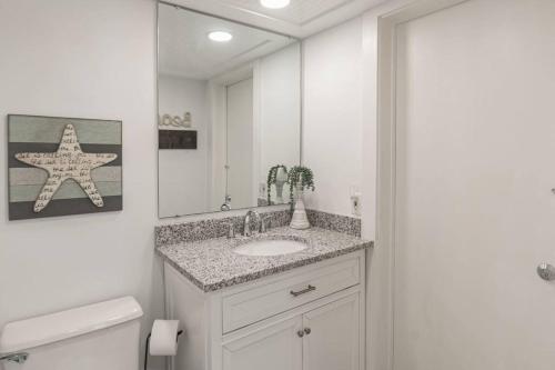a white bathroom with a sink and a mirror at Turtle View Villa in Hilton Head Island