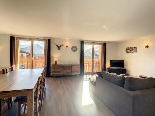 un salon avec un canapé et une table dans l'établissement Appartement 2* 8 pers, proche télésiège, balcon sud, parking, commerces à proximité - FR-1-417-17, à La Toussuire