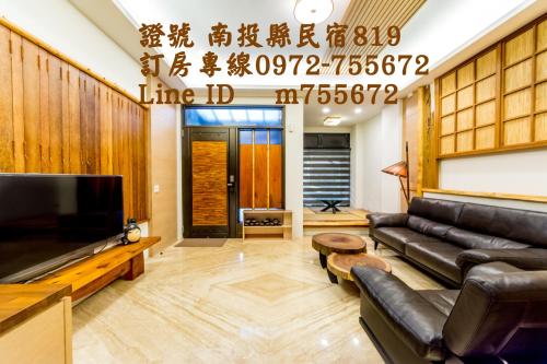 a living room with a couch and a tv at 榛品包棟民宿 in Puli