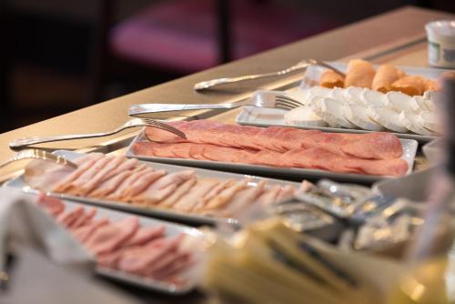 a table topped with different types of meats and food at Hotel Montana in Geneva