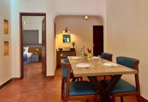 a dining room with a table and blue chairs at Adrak Mountain Mist Forest Resort in Pulpally