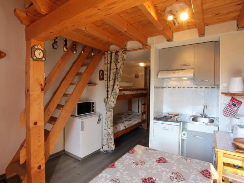 une petite cuisine avec un escalier dans une petite maison dans l'établissement Studio cosy avec mezzanine, balcon sud proche télésiège, Fontcouverte-la-Toussuire - FR-1-417-53, à La Toussuire
