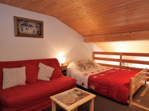 - une chambre avec un lit et un canapé rouge dans l'établissement Studio cosy avec mezzanine, balcon sud proche télésiège, Fontcouverte-la-Toussuire - FR-1-417-53, à La Toussuire