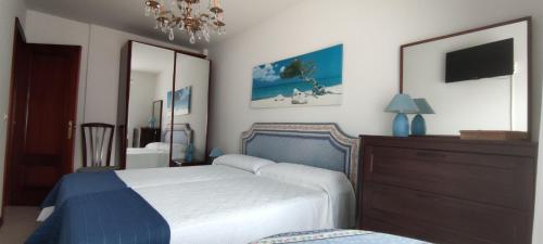 Кровать или кровати в номере Acogedor apartamento en la playa de Trengandín también para tu mascota