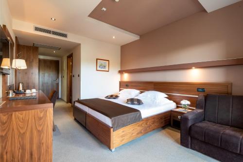 a bedroom with a large bed and a couch at Hotel Plaža in Omiš
