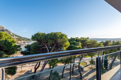 a balcony with a view of a beach and trees at Hotel Plaža in Omiš