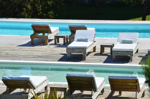 a group of chairs and tables next to a pool at Casa Suaya in José Ignacio
