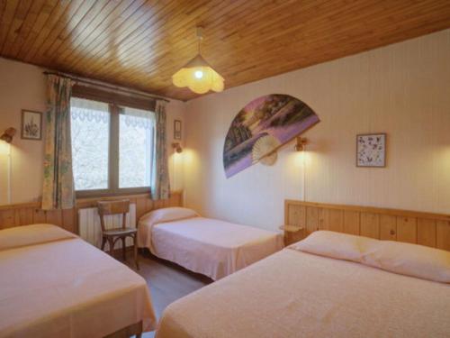 - une chambre avec 3 lits, une table et des chaises dans l'établissement Appartement spacieux 2 chambres, skis aux pieds, parking, WIFI – La Toussuire - FR-1-417-146, à La Toussuire