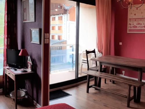 un salon avec une table et une fenêtre dans l'établissement Charmant appart 4 pers avec balcon et parking au cœur de la station - FR-1-417-145, à La Toussuire