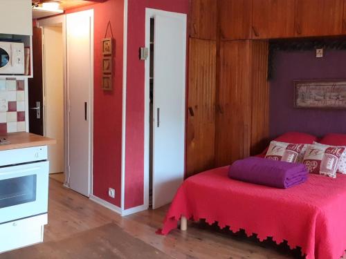une chambre avec un lit avec une couverture rouge dans l'établissement Charmant appart 4 pers avec balcon et parking au cœur de la station - FR-1-417-145, à La Toussuire