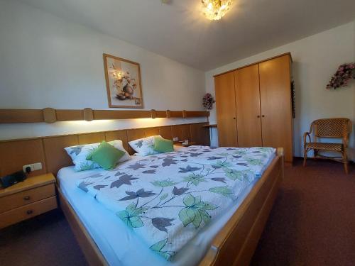 een slaapkamer met een groot bed en een blauwe deken bij Haus am Forstamt 11 Ferienwohnungen in Ramsau