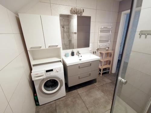 a bathroom with a washing machine and a sink at Serce miasta -Mostowa Bydgoszcz in Bydgoszcz