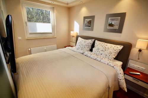 ein Schlafzimmer mit einem großen Bett und einem Fenster in der Unterkunft Seepferdchen Suite in Timmendorfer Strand