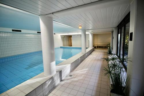 a swimming pool in a building with a pool at Seepferdchen Suite in Timmendorfer Strand