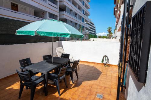 a table and chairs with an umbrella on a patio at Casa Sami in Playa de las Americas