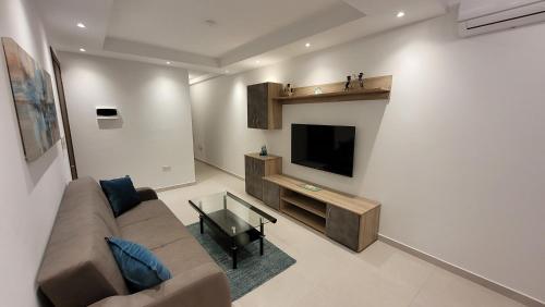 a living room with a couch and a flat screen tv at Lovely Apartment with Side Sea View in St. Paul's Bay