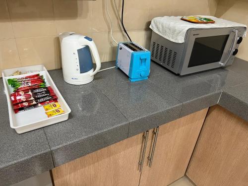 a kitchen counter with a microwave and a toaster at D’Lestari Homestay in Seri Kembangan