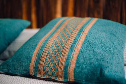 a blue pillow sitting on a couch with two blue pillows at Niyana Oaxaca in Oaxaca City
