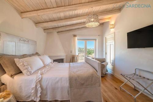 1 dormitorio con 1 cama y TV de pantalla plana en Tenute Shardana Luxury Farmhouse with SPA, Sauna, Heated Swimming Pool en Mores