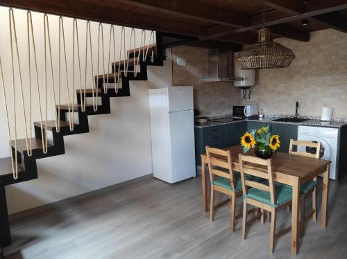 uma cozinha com uma mesa e cadeiras e uma escadaria em Casa el Recreo em Jérica