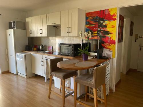 uma cozinha com uma mesa com cadeiras e um frigorífico em Océan front apartment em Cannes