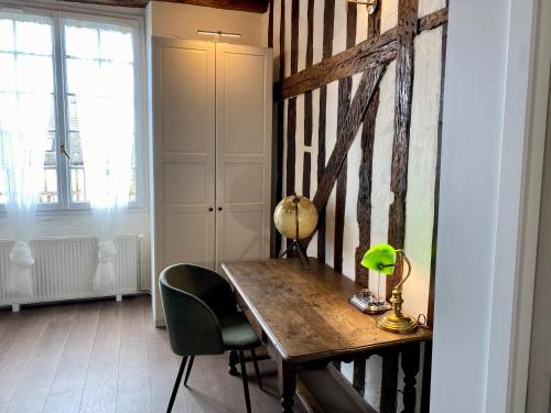 Cette chambre comprend une table en bois et une chaise. dans l'établissement Le repaire d'Esmeralda, à Orléans