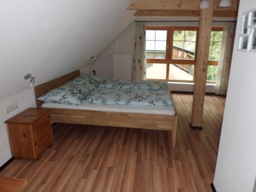 Schlafzimmer mit einem Bett und Holzboden in der Unterkunft Fewo-Lenz in Hermagor