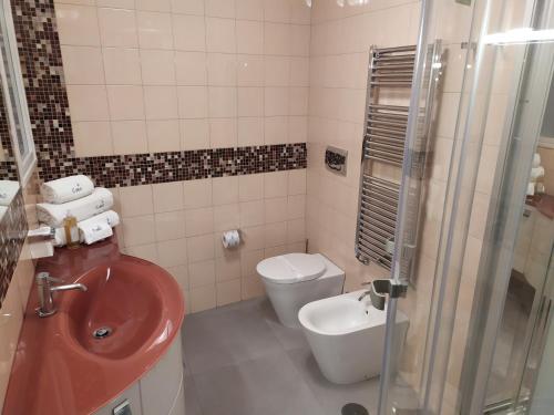 La salle de bains est pourvue d'un lavabo rouge et de toilettes. dans l'établissement Cubo Apartments, à Vico Equense