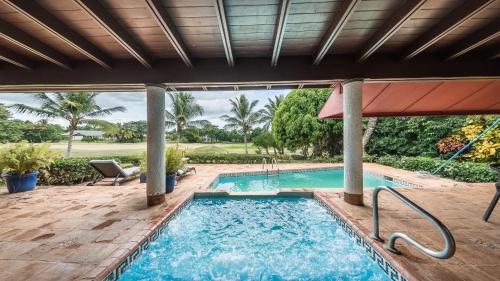 una piscina con patio y sombrilla en Mesmerizing 5 BR Villa at Casa de Campo, en Cajuiles