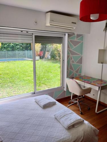 1 dormitorio con cama, escritorio y ventana en Casa ideal para familia, a minutos de Buenos Aires en Martínez