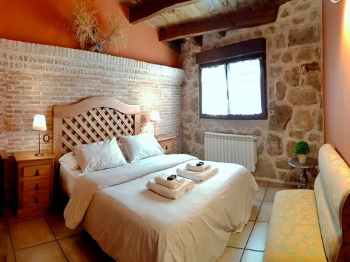 1 dormitorio con 1 cama con toallas en El Patio de Valentina, en Navacerrada