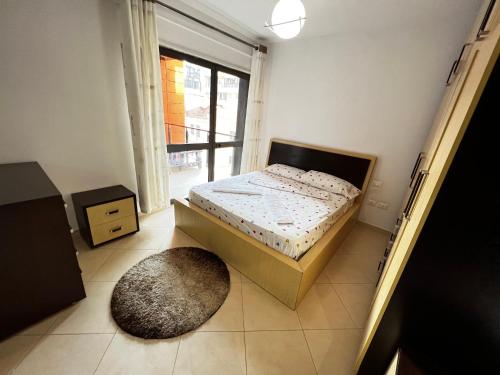 a small bedroom with a bed and a rug at Grande Veranda 2 in Tirana