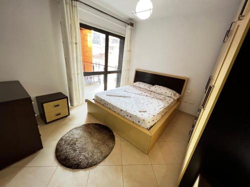une petite chambre avec un lit et un tapis dans l'établissement Grande Veranda 2, à Tirana