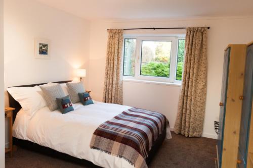 a bedroom with a bed and a window at An Cala Beag Self Catering apartment on The Waternish Peninsula in Hallin
