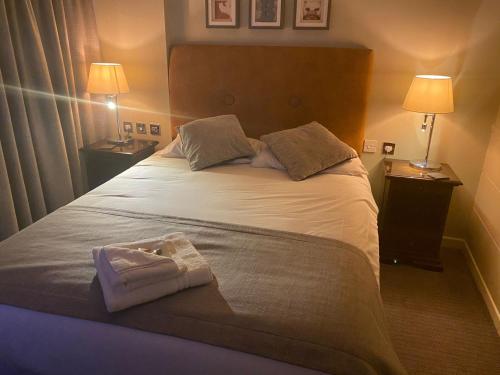 a bedroom with a large white bed with two lamps at The Belmore in Sale