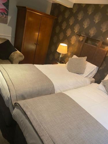 a hotel room with two beds and a lamp at The Belmore in Sale