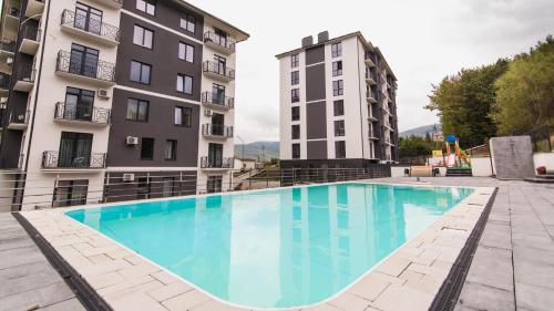 a large swimming pool in the middle of two buildings at Апартаменти у Сонячному Закарпатті in Polyana