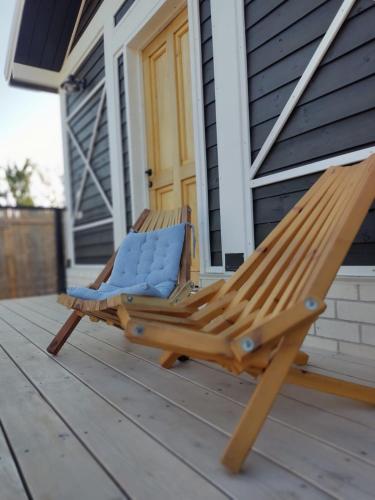 a wooden deck with a chair on a porch at Wooden Zimmer El-Rom in El-Rom