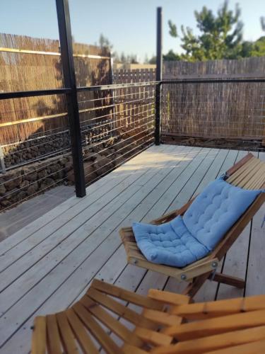 a chair with a blue cushion on a deck at Wooden Zimmer El-Rom in El-Rom