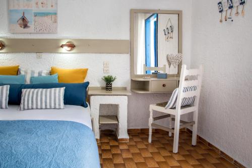 a bedroom with a bed and a desk and a chair at Amazona in Agia Pelagia