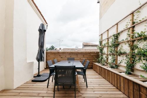 een patio met een tafel en stoelen op een balkon bij Avenue Ferry in Libourne