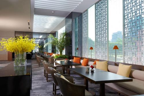 a restaurant with tables and chairs and large windows at Regent Taipei in Taipei
