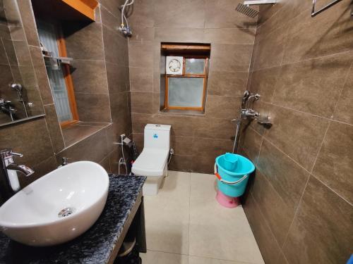 a bathroom with a sink and a toilet at Family Retreat - The Forest Dak Bangalow in Rāmgarh