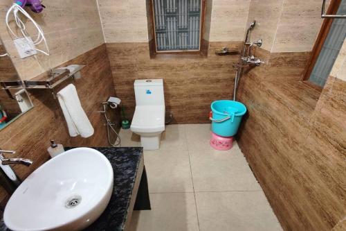 a bathroom with a sink and a toilet and a tub at Family Retreat - The Forest Dak Bangalow in Rāmgarh