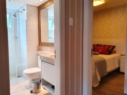 uma casa de banho com um lavatório, um WC e uma cama em Ape St Petrus Centro Gramado em Gramado