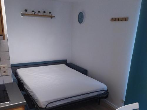 Cette petite chambre comprend un lit blanc. dans l'établissement studio 21, à Rochefort