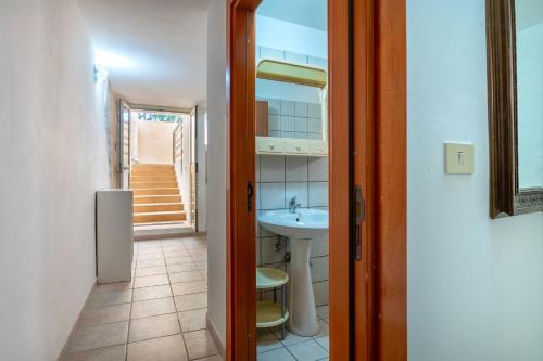 een badkamer met een wastafel en een spiegel bij Appartamento Acquadolce in Torre Ovo